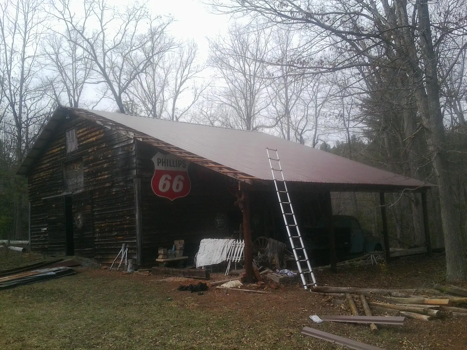 New metal roof on an open sided timber barn with a vintage sign in Foristell