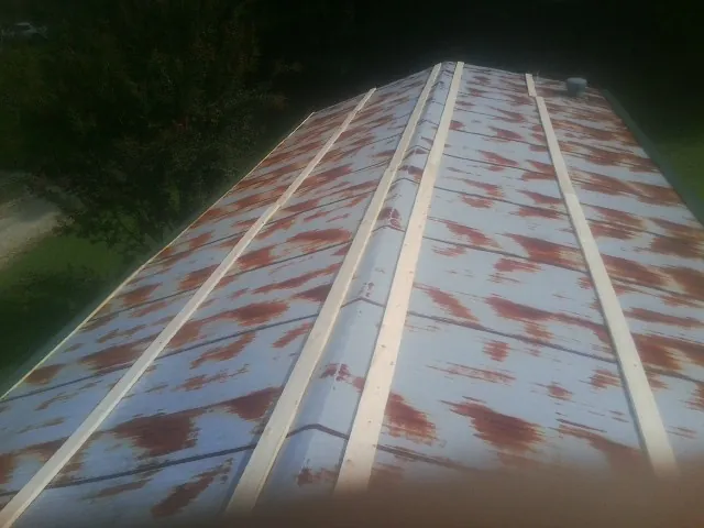 Rusted metal roof panels with new wood purlins before replacement — Storm Damage Roof Repair in Foristell by Roofing Brothers