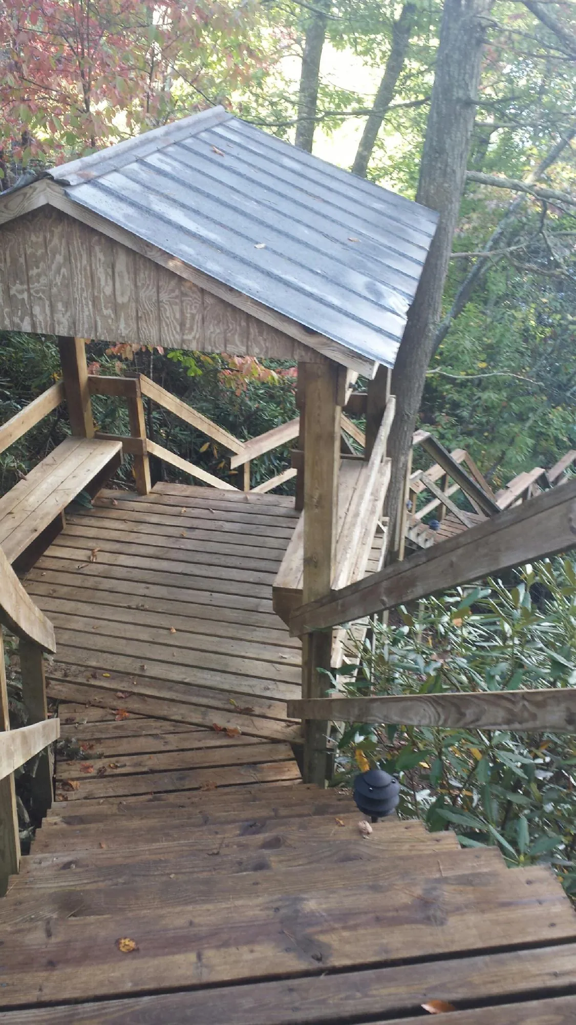 Metal roofed shelter over wooden steps on a wooded walkway — Skylight Repair & Installation work by our crew in Foristell