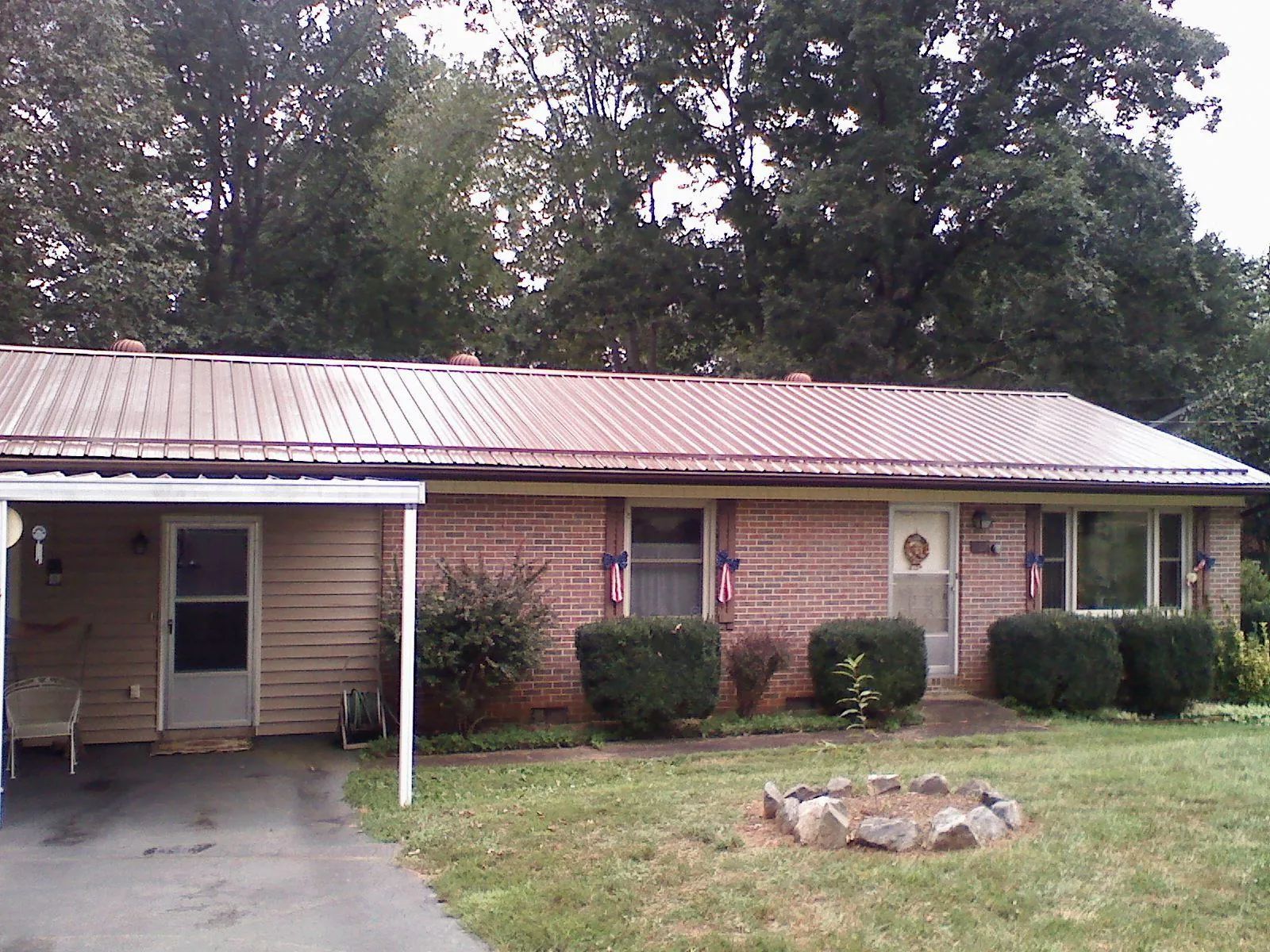 Bronze metal roof and carport on a brick ranch home — Roof Repair work by our crew in Foristell